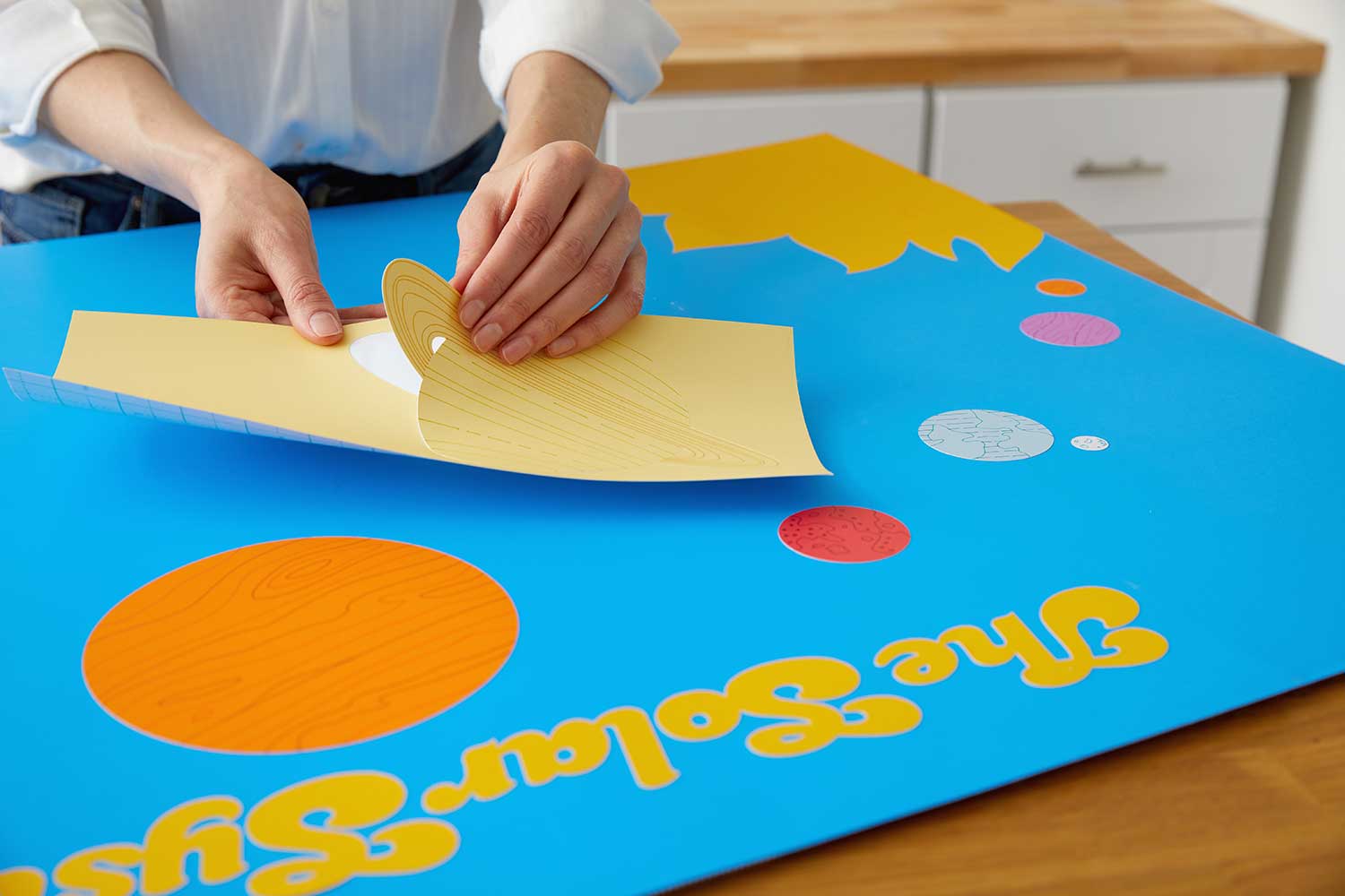 teacher preparing a solar system poster using Cricut