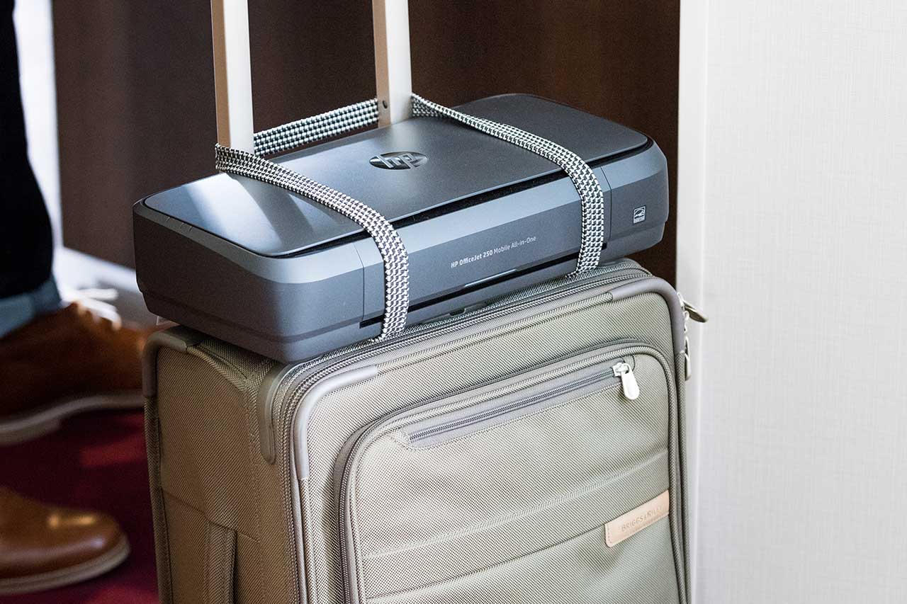 HP OfficeJet 250 portable printer strapped on a suitcase ready to travel