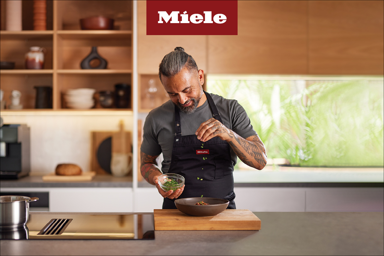 A cook works in a kitchen with Miele appliances
